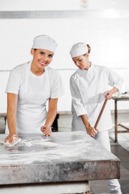 Bayan Baker Temizleme tablo iş arkadaşınız kullanarak paspas fırın içinde iken