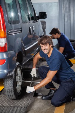Tamirci Atölyesi'nde otomobil lastiği jant anahtar ile sabitleme