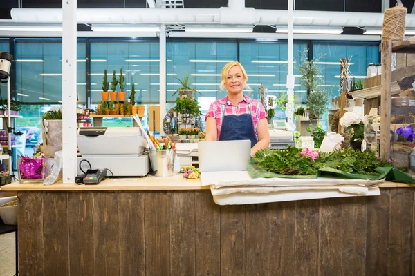 Glad Florist står vid disken i blomma lagra — Stockfoto