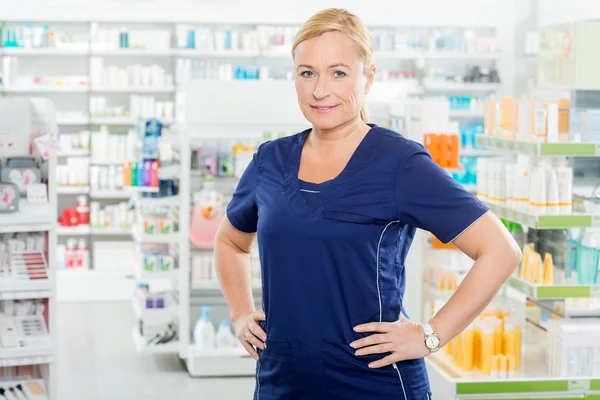 Femme chimiste debout avec les mains sur la hanche en pharmacie — Photo