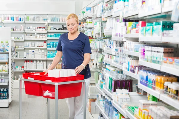 Químico con productos en cestas en la farmacia — Foto de Stock