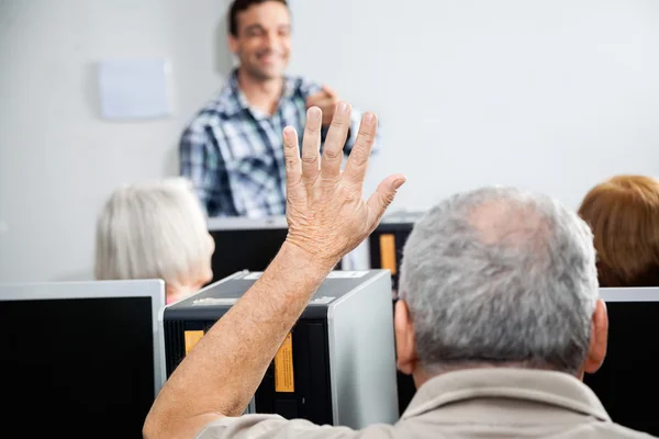 Homme âgé posant une question en classe d'informatique — Photo