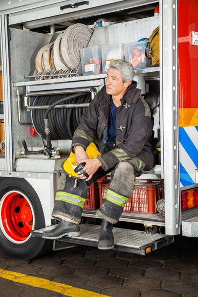 Nachdenklicher Feuerwehrmann sitzt im LKW — Stockfoto