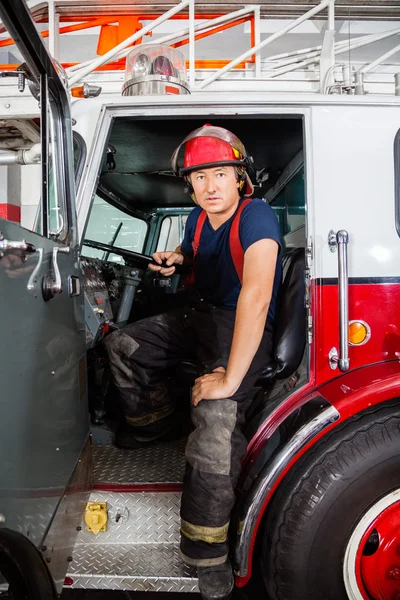 Selbstbewusster Feuerwehrmann sitzt in LKW — Stockfoto