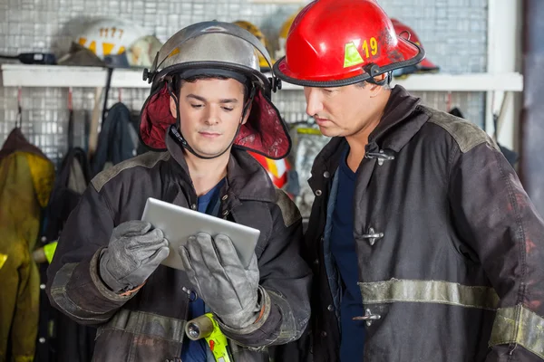 Brandweerlieden met behulp van digitale Tablet op brandweerkazerne — Stockfoto