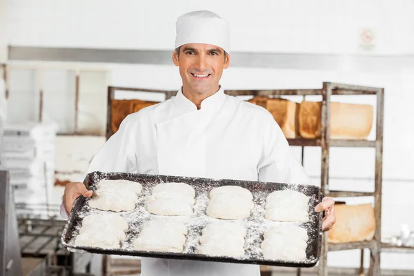 Selbstbewusster Bäcker hält Backblech — Stockfoto