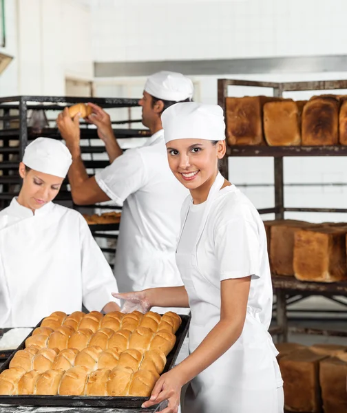 Selbstbewusste Bäckerin mit gebackenem Brot — Stockfoto