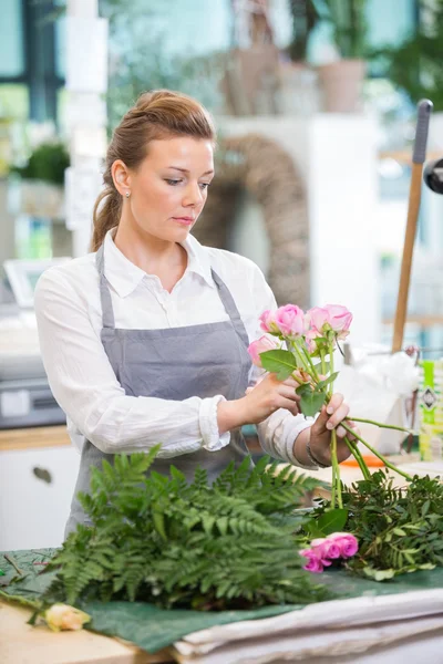 Florista fazendo buquê de rosa na loja de flores — Fotografia de Stock