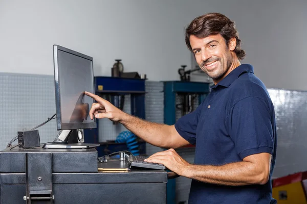 Μηχανικός, αγγίζοντας την οθόνη υπολογιστή στο κατάστημα επισκευής — Φωτογραφία Αρχείου