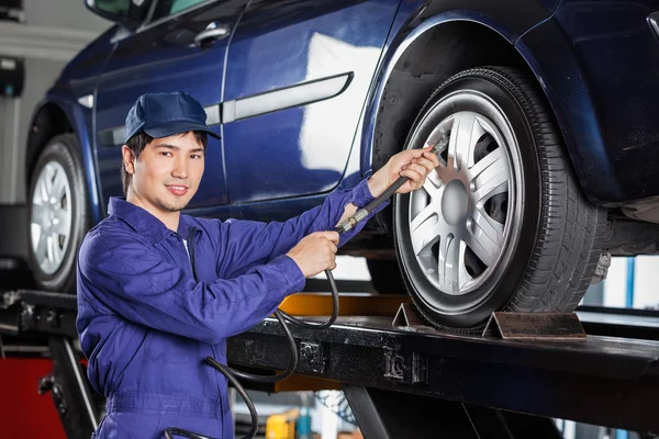 Ar de enchimento mecânico no pneu do carro na garagem — Fotografia de Stock