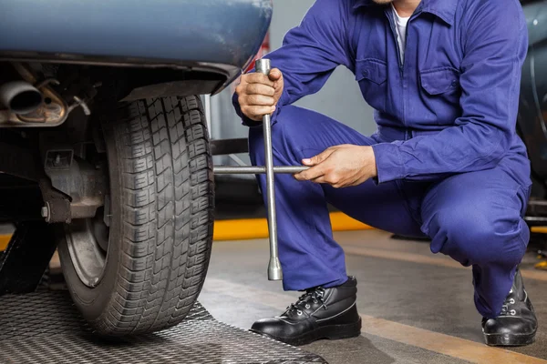 Mekaniker fixa bildäck med fälg skiftnyckel — Stockfoto