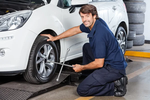 Portrait Of Mechanic Fixing Car Tire at Garage — стоковое фото