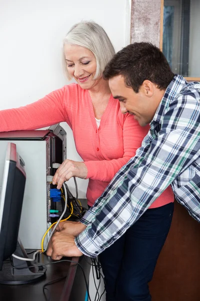 Handledare hjälpa seniore elev konfigurera dator — Stockfoto