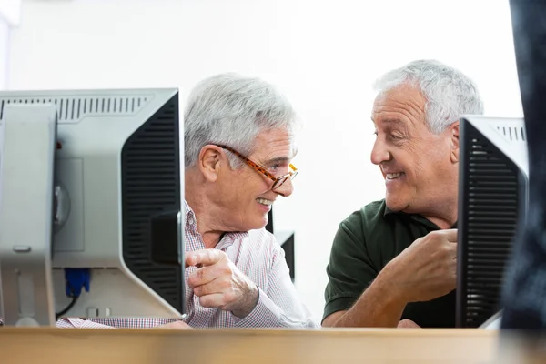 Starszych kolegów mówić na biurku komputer w klasie — Zdjęcie stockowe