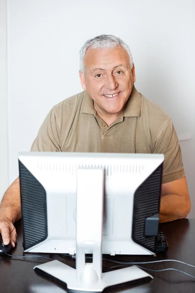 Homem Sênior feliz usando o computador na sala de aula — Fotografia de Stock