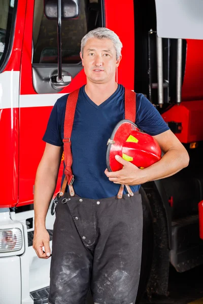 赤いヘルメットを保持するいると確信しての消防士 — ストック写真