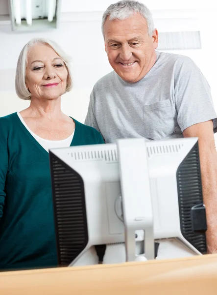 Personas mayores felices usando la computadora en el aula — Foto de Stock