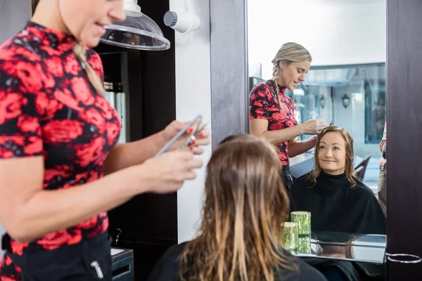 Feliz mujer consiguiendo corte de pelo en salón de belleza — Foto de Stock