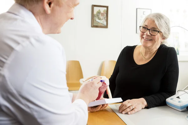 Paciente olhando para o médico masculino explicando ombro manguito rotador — Fotografia de Stock