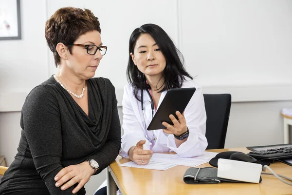 Medico serio che mostra tavoletta digitale al paziente — Foto Stock