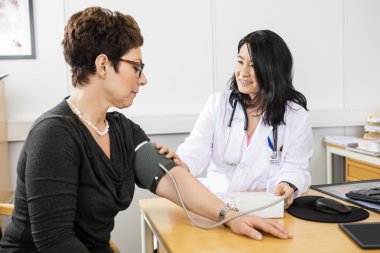Doktor kadın hastaların kan basıncı incelenmesi