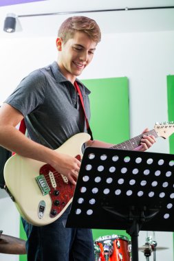 Adam gitar nota bakarken