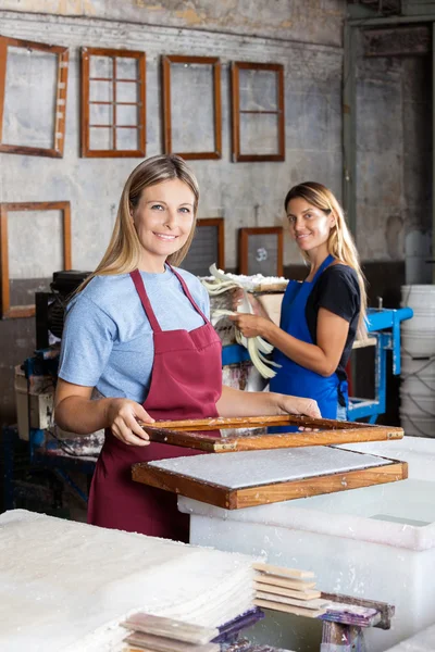 Vrouwelijke werknemers maken van papieren samen In fabriek — Stockfoto