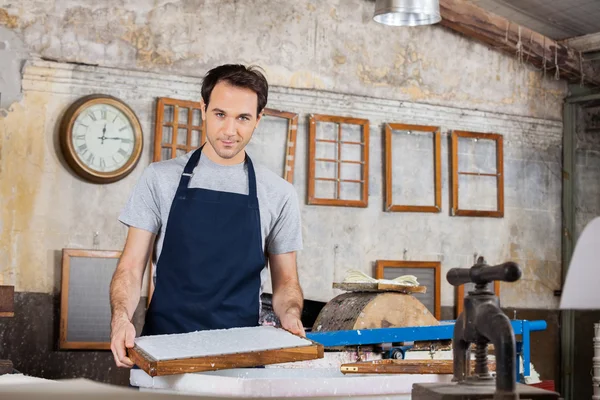 Lavoratore fiducioso che tiene la muffa alla fabbrica di carta — Foto Stock