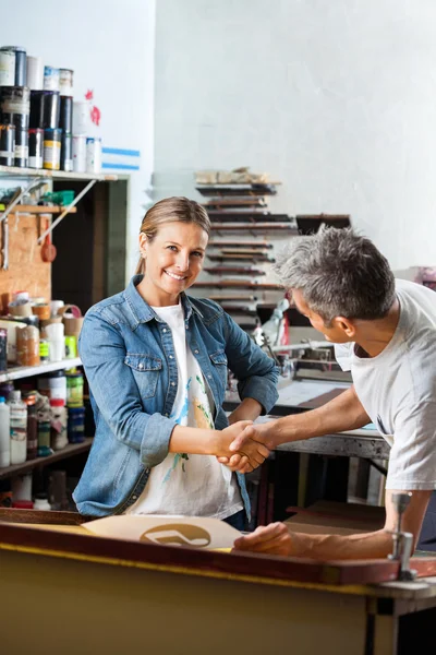 Lächelnder Arbeiter schüttelt Kollegen in der Fabrik die Hand — Stockfoto