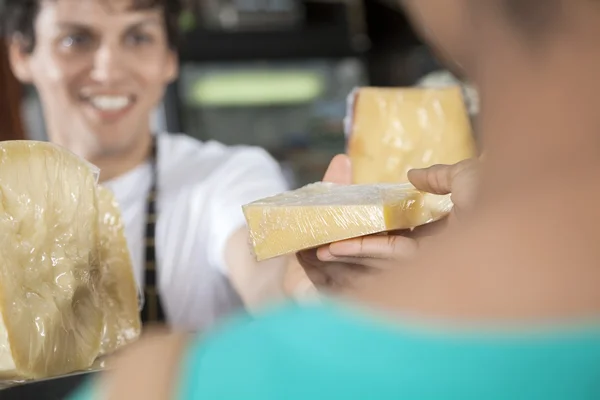 Gelukkig verkoper verkopen van kaas aan vrouwelijke klant — Stockfoto