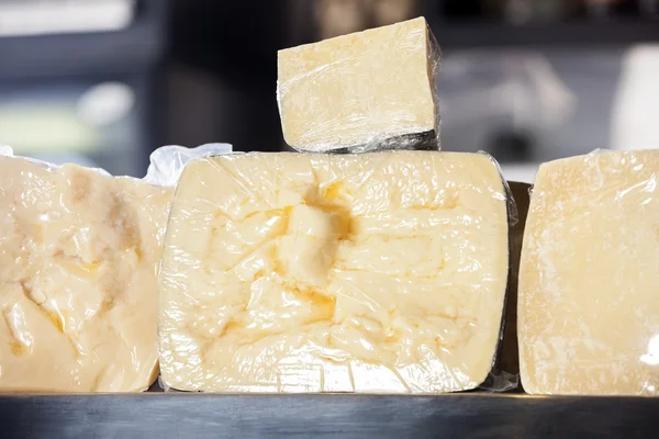Pedaços de queijo exibidos na loja — Fotografia de Stock