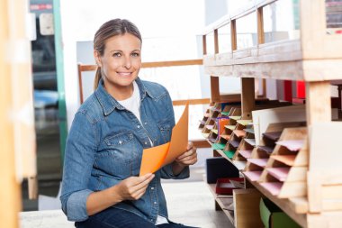 Kağıtları dükkanda tutan gülümseyen kadın müşteri