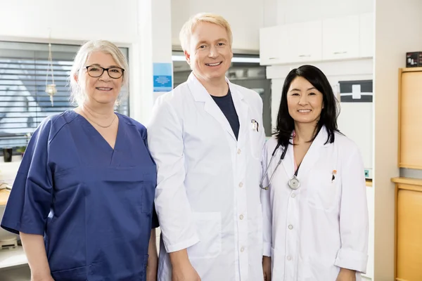Equipo médico multiétnico sonriendo juntos en el hospital —  Fotos de Stock