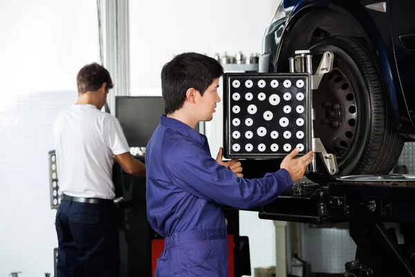 Mechanik užívající vyrovnávač kola na auto — Stock fotografie