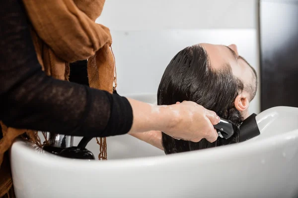 Hombre teniendo cabello lavado en salón de belleza — Foto de Stock