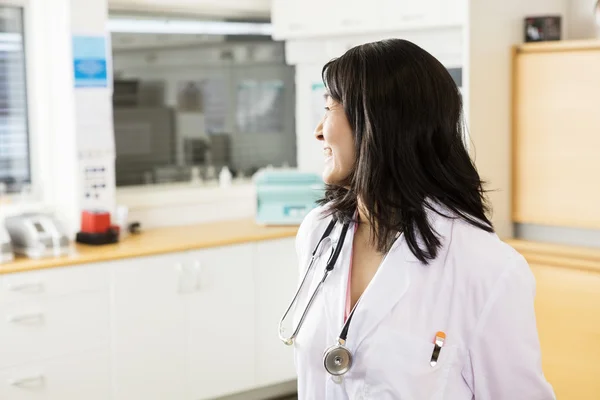 Läkaren tittar bort medan stående i kliniken — Stockfoto