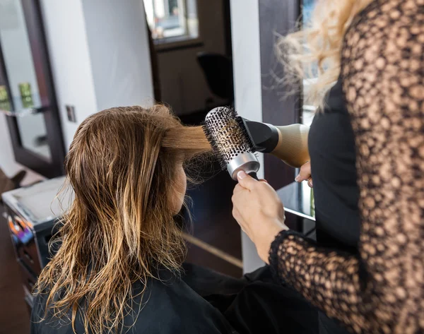 Friseur stylt Kunden Haare im Salon — Stockfoto