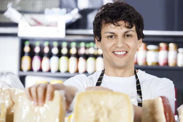 Kendine güvenen satıcı peynir dükkanında düzenlenmesi — Stok fotoğraf