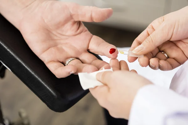 Médecin prélever un échantillon de sang du patient en clinique — Photo