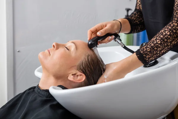 Vrouw om haar gewassen In Salon — Stockfoto