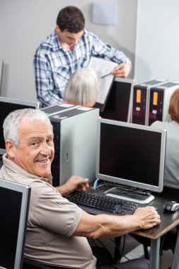 Sınıfta Compute kullanan mutlu üst düzey adam portresi