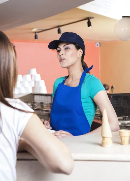 Официантка смотрит на девушку в магазине мороженого — стоковое фото