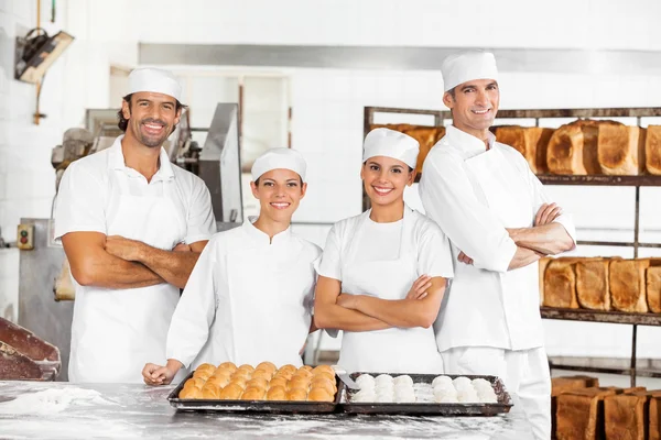 Vertrouwen mannelijke en vrouwelijke bakkers permanent aan tafel — Stockfoto