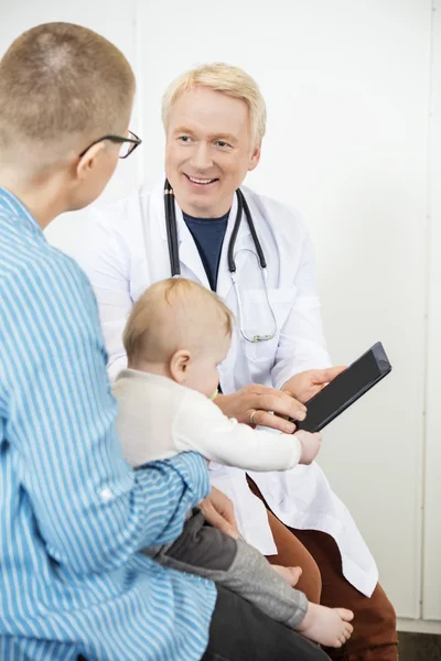 Mannelijke kinderarts digitale Tablet tonen aan vrouw met Baby — Stockfoto