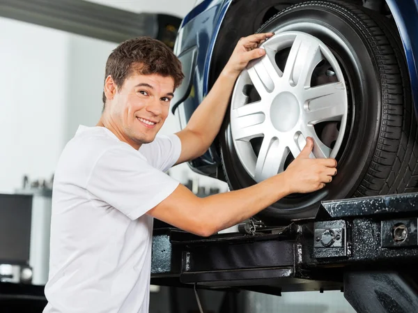 Happy mechanik upevnění trysky na auto pneumatiky — Stock fotografie