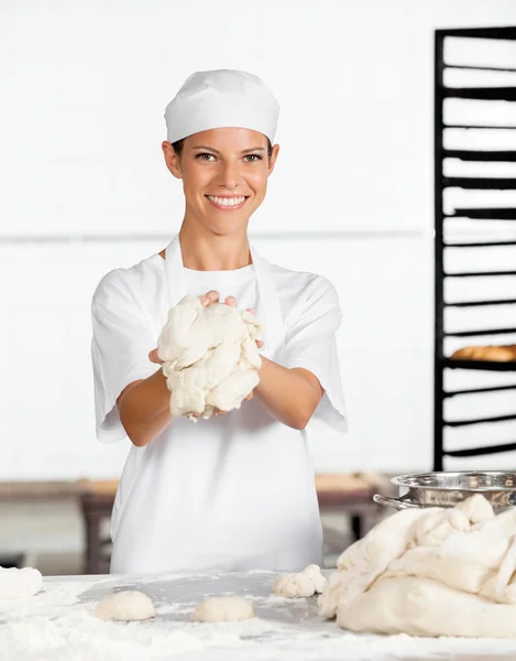 Female Baker Showing Dough At Table — Stock Photo, Image