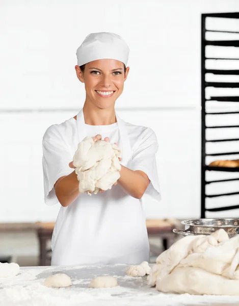 Bäckerin zeigt Teig am Tisch — Stockfoto