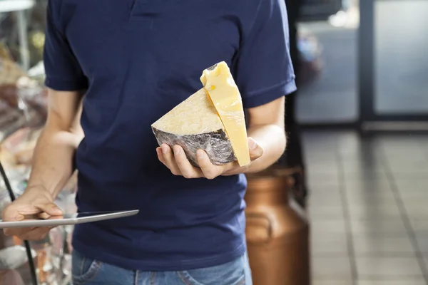 Man Holding Cheese And Digital Tablet In Grocery Store — Stock Photo, Image