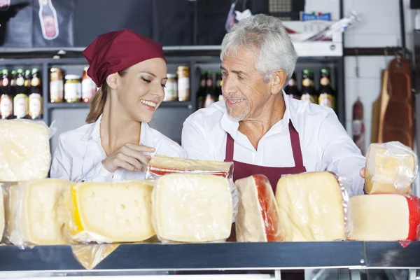 Colleagues Discussing While Holding Cheese In Store — Stock Photo, Image