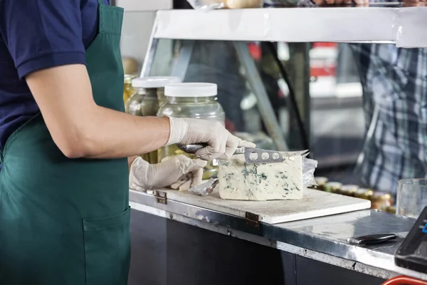 Venditore affettare formaggio blu con coltello — Foto Stock